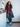 Woman wearing a plaid coat and pink fur scarf in a kitchen setting and th emost visible cloth is her shoes, the Air Max 95 "Neon"